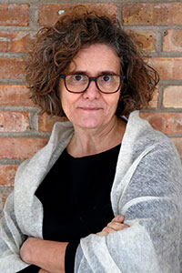 Woman with curly hair, black shirt, and white shawl
