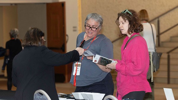 Three women in black grey and pink shirts