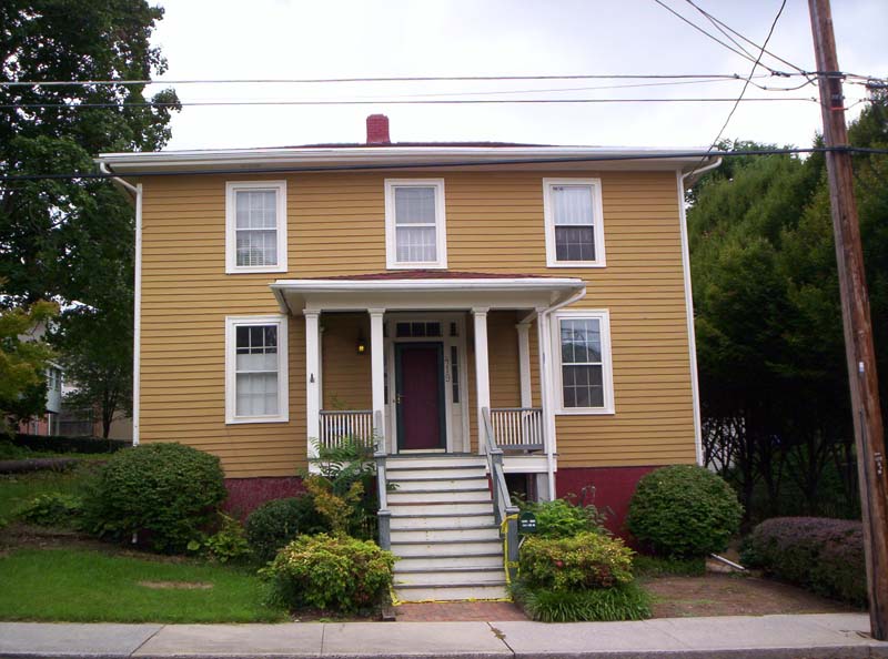 two-story brown house with white steps to front door