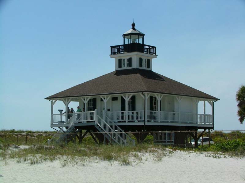 white wood frame lighthouse on a beach