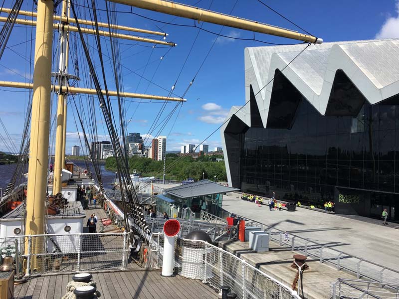 ship docked alongside modern angular building